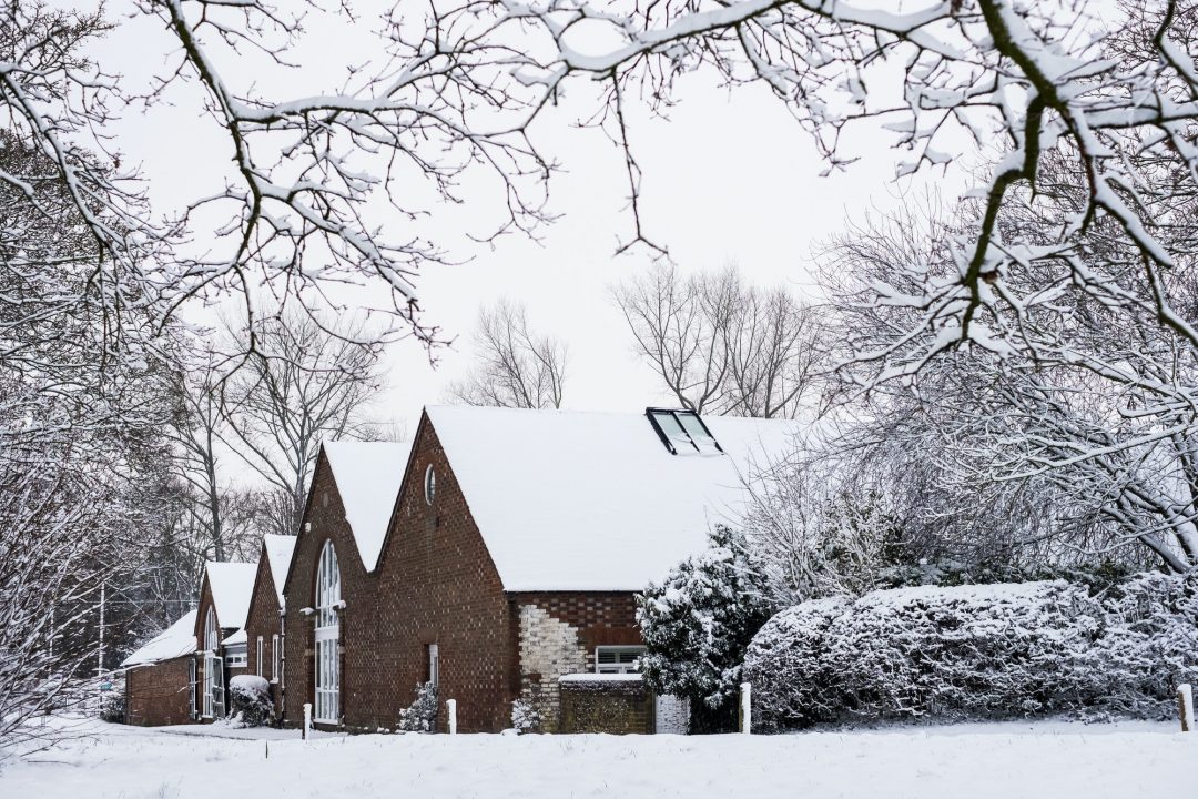 exterior view of red brick cottages with snow covered roofs along a rural road .jpg